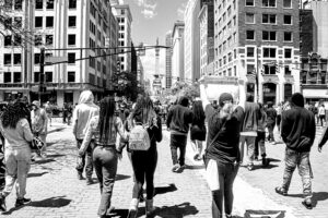 Black and white photo of protesters with signs marching in downtown Indianapolis.