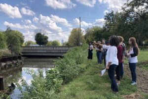 Group of college-age students walking along White River.