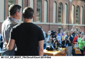 Two men standing in front of a crowd speaking