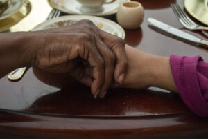 Close up of two hands holding each other.